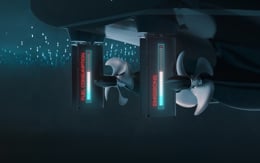 Close-up view of twin ship propellers mounted beneath a vessel, each paired with a vertical thruster unit labeled “PM Control System” and “EMISSION.”