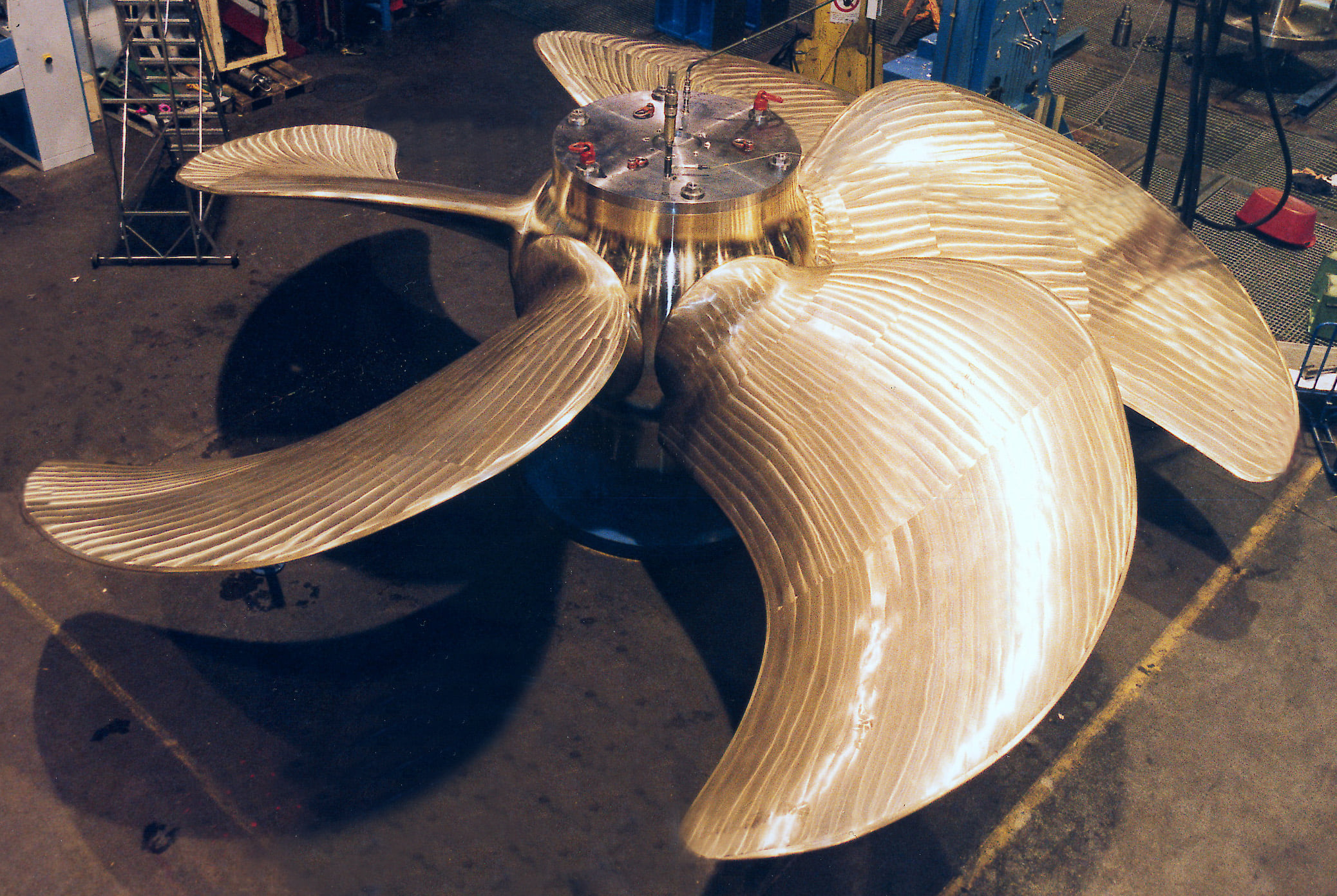 Large ship propeller with five blades on a hub in a workshop environment