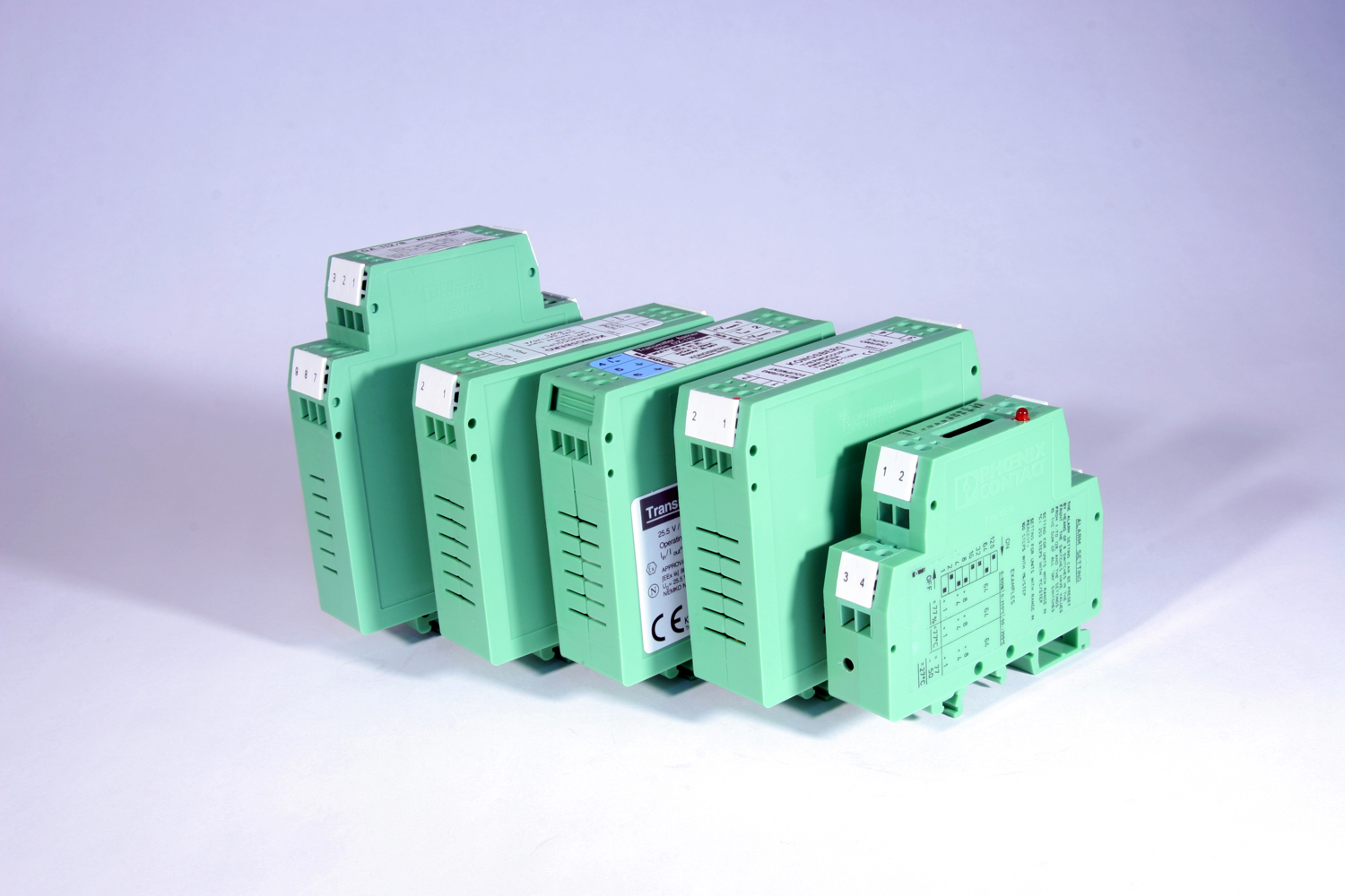 Set of green industrial DIN rail-mounted modules arranged in a row on a light background.