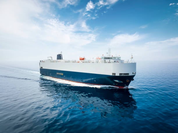 A photograph of a car carrier vessel sailing in calm seas