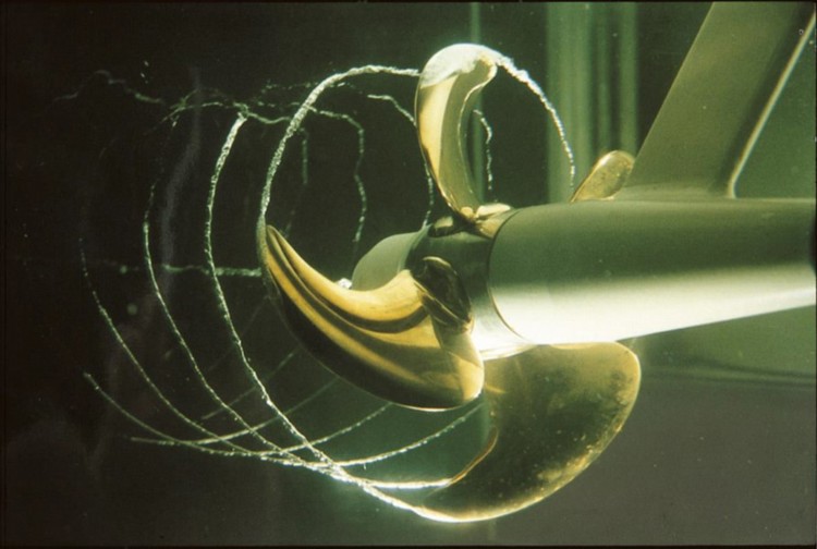 Marine propeller in operation revealing cavitation and vortex patterns forming around the rotating blades in test environment