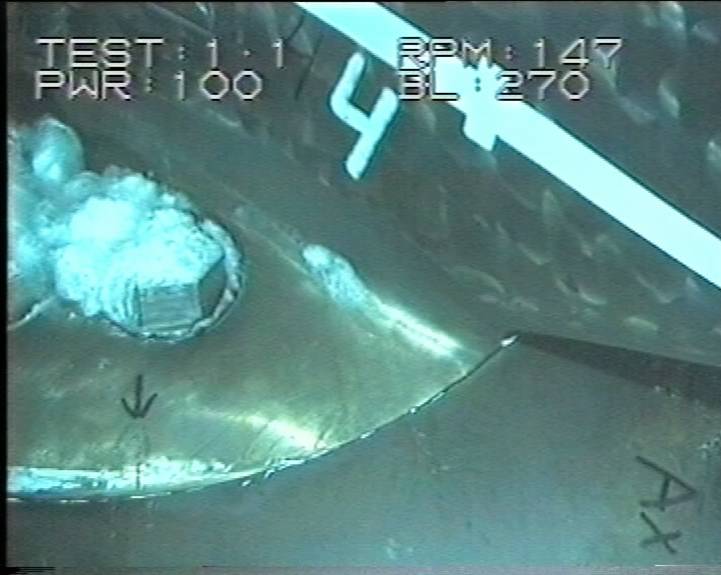 Underwater cavitation on a ship propeller blade surface, showing bubbles forming on the metal surface during operation
