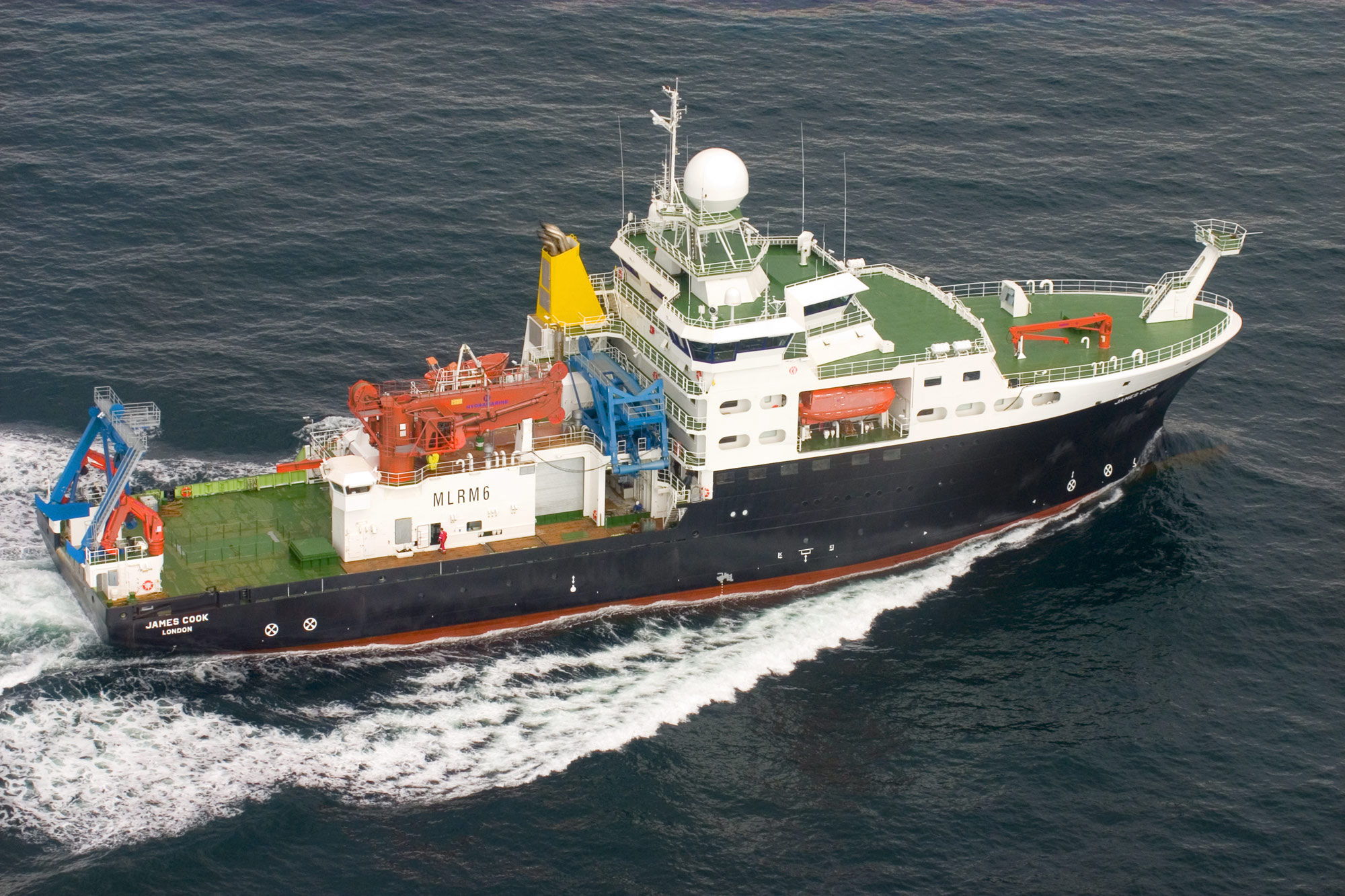 An aerial photo shows a survey vessel motoring in relatively calm seas